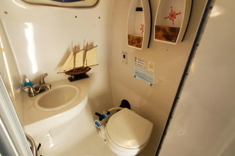 Slide: The Image of 1997 Chaparral Signature 240 boat bathroom with sink, toilet, and nautical decor. - 15