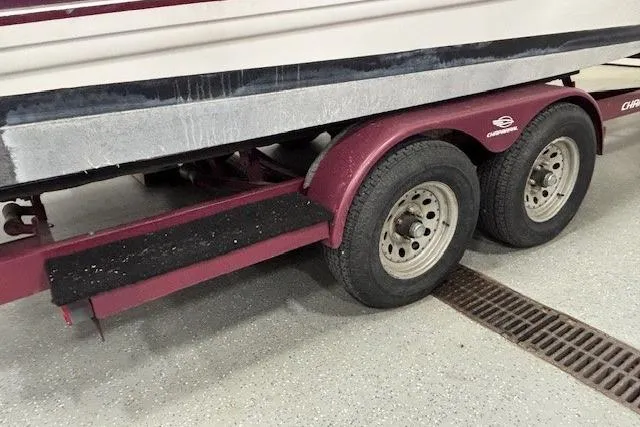 Slide: The Image of 1997 Chaparral Signature 240 boat trailer with dual wheels in a garage setting. - 28