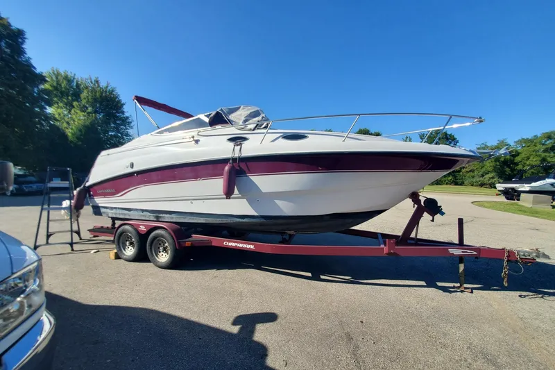 Slide: The Image of 1997 Chaparral Signature 240 boat on trailer, parked outdoors under clear blue sky. - 3