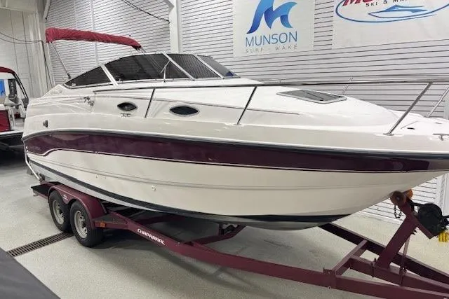 Slide: The Image of 1997 Chaparral Signature 240 boat on trailer in showroom, white with maroon accents. - 31
