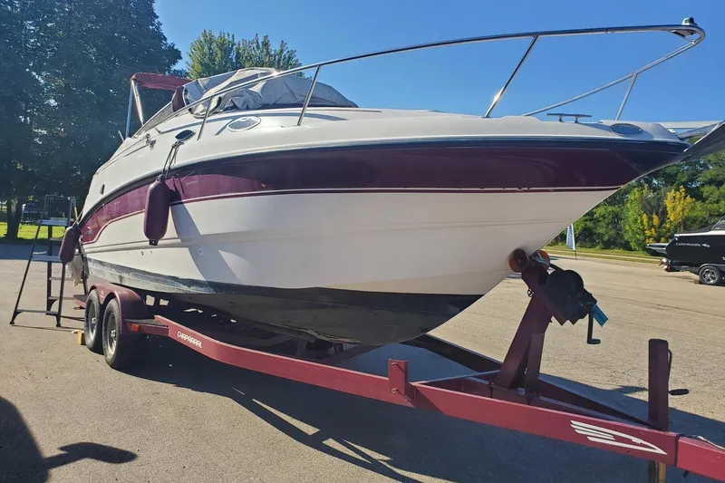 Slide: The Image of 1997 Chaparral Signature 240 boat on trailer, parked outdoors under clear blue sky. - 4