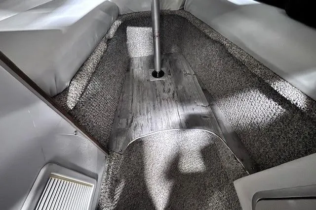 Slide: The Image of Interior cabin of a 1997 Chaparral Signature 240 boat, featuring carpeted flooring and seating. - 43