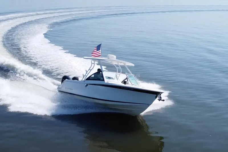 Slide: The Image of 2021 Blackfin 252 DC boat cruising on open water with American flag. - 1