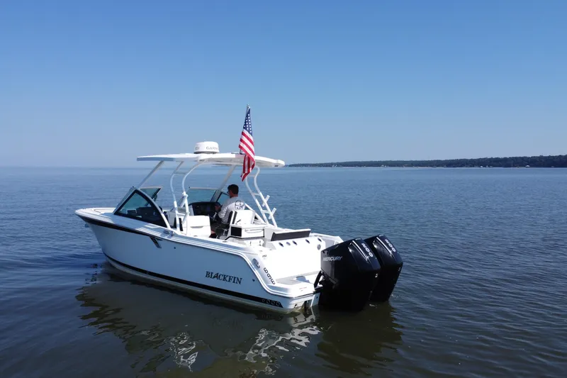 Slide: The Image of 2021 Blackfin 252 DC boat on calm water with American flag. - 11