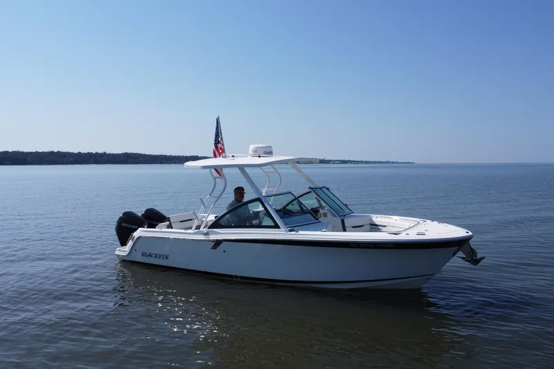Slide: The Image of 2021 Blackfin 252 DC boat on calm water with clear blue sky. - 12