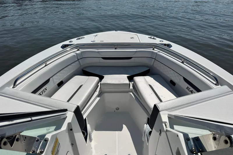 Slide: The Image of 2021 Blackfin 252 DC boat interior with cushioned seating on calm water. - 20