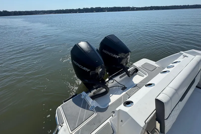Slide: The Image of 2021 Blackfin 252 DC boat with dual Mercury outboard engines on a calm lake. - 31