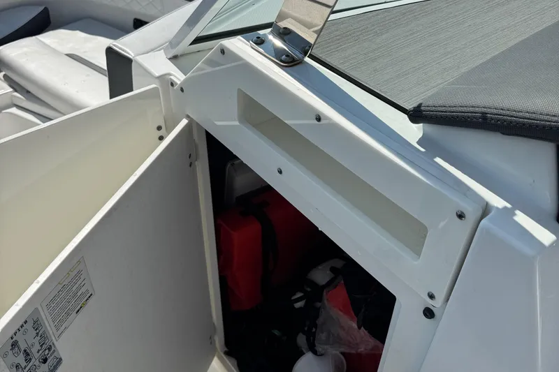 Slide: The Image of Open storage compartment on 2021 Blackfin 252 DC boat, showing safety equipment inside. - 36
