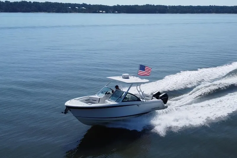 Slide: The Image of 2021 Blackfin 252 DC boat cruising on a lake with an American flag. - 6