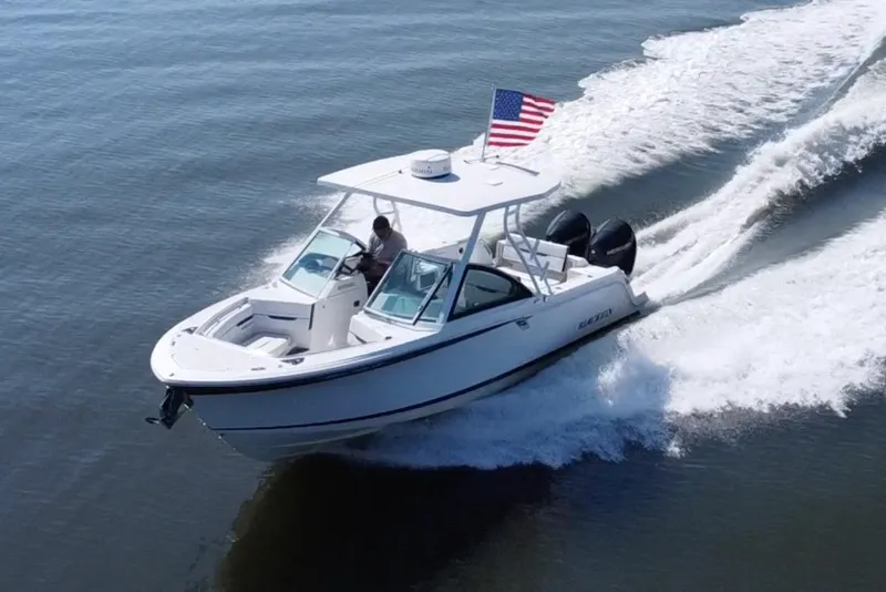 Slide: The Image of 2021 Blackfin 252 DC boat cruising on water with American flag. - 7