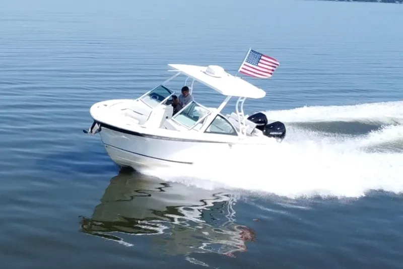 Slide: The Image of 2021 Blackfin 252 DC boat cruising on calm water with American flag. - 8