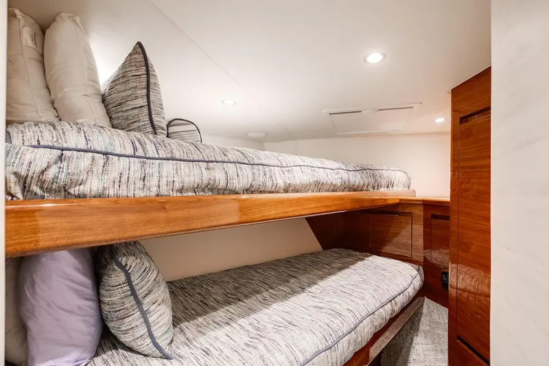 Slide: The Image of 2025 Viking 48 Convertible yacht interior with cozy bunk beds and wooden finishes. - 24