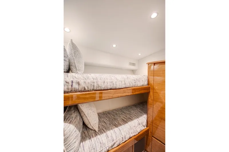 Slide: The Image of Bunk beds in 2025 Viking 48 Convertible yacht cabin, featuring modern design and wood finish. - 25