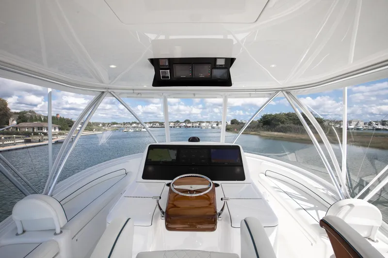 Slide: The Image of 2025 Viking 48 Convertible yacht helm with panoramic waterway view. - 31