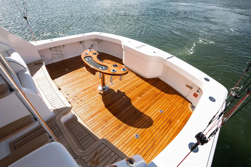 Slide: The Image of Luxurious 2025 Viking 48 Convertible yacht deck with teak flooring and fishing rod holders. - 36