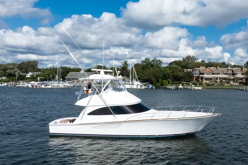 Slide: The Image of 2025 Viking 48 Convertible yacht cruising on a scenic waterfront with blue skies. - 4