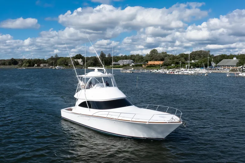 Slide: The Image of 2025 Viking 48 Convertible yacht cruising on a scenic lake under a blue sky. - 5