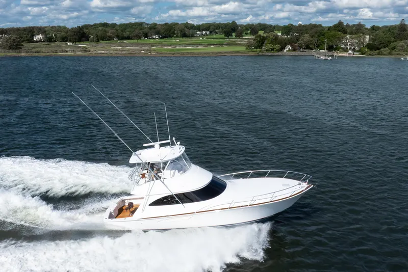 Slide: The Image of 2025 Viking 48 Convertible yacht cruising on a scenic waterway. - 6