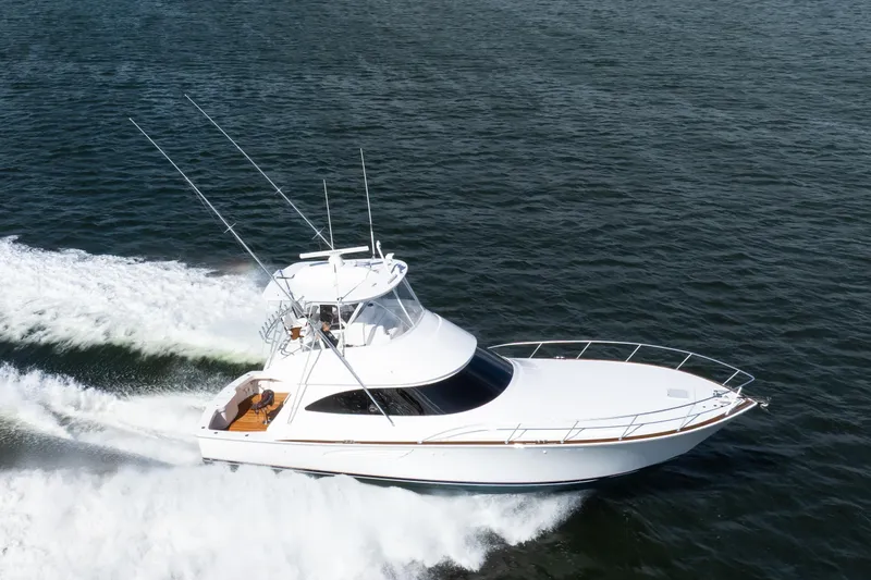 Slide: The Image of 2025 Viking 48 Convertible yacht cruising swiftly on open water. - 7