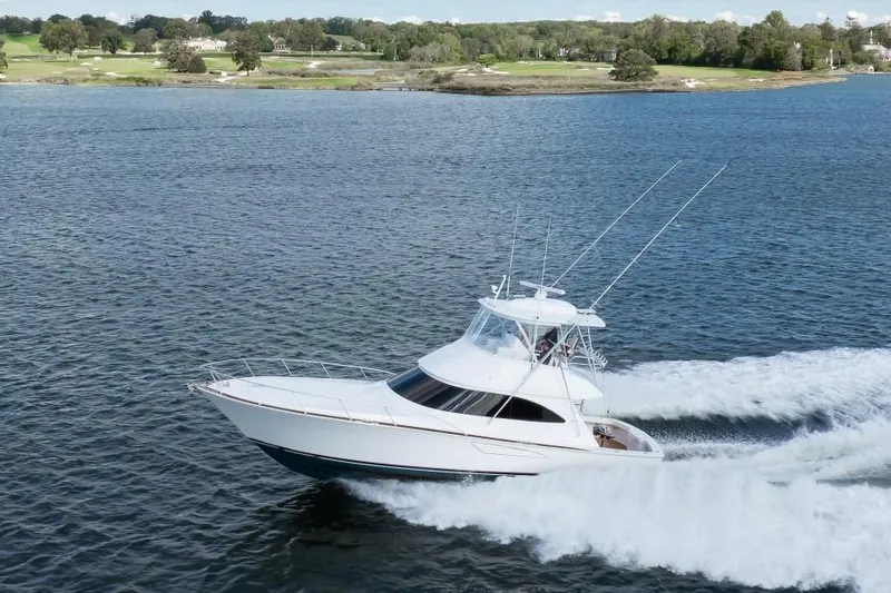 Slide: The Image of 2025 Viking 48 Convertible yacht cruising on a scenic lake. - 8