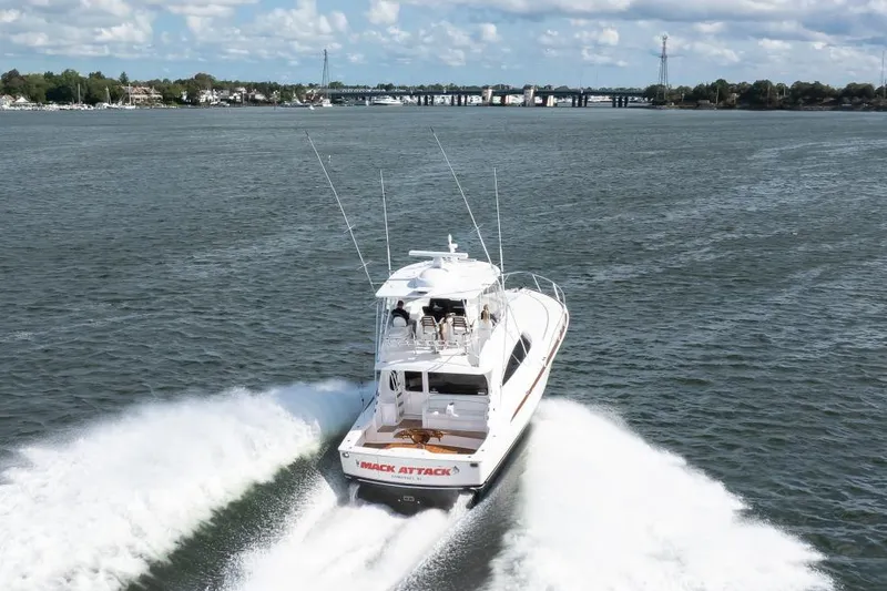 Slide: The Image of 2025 Viking 48 Convertible yacht cruising on open water, creating a wake. - 9