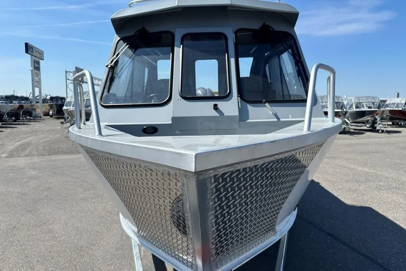 Slide: The Image of 2025 Hewescraft 210 Sea Runner ET HT boat, front view, parked outdoors. - 2