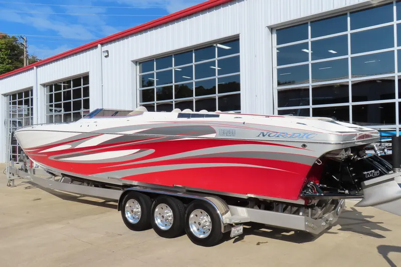 Slide: The Image of 2013 Nordic 39 Poker Run boat with red and white design, parked on a trailer. - 3