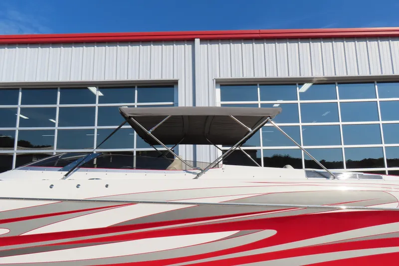 Slide: The Image of 2013 Nordic 39 Poker Run boat with red and white design, parked near a building. - 6