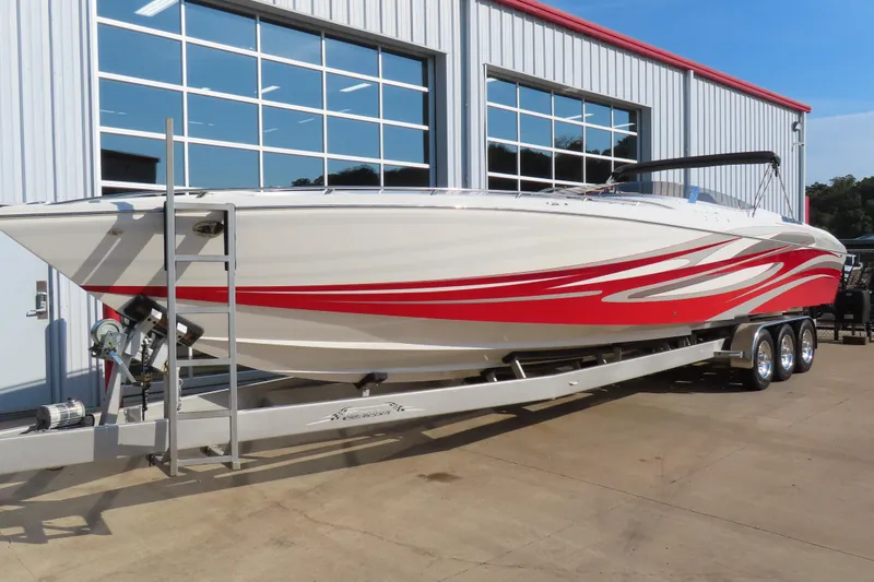Slide: The Image of 2013 Nordic 39 POKER RUN boat with red accents on a trailer outside a building. - 9
