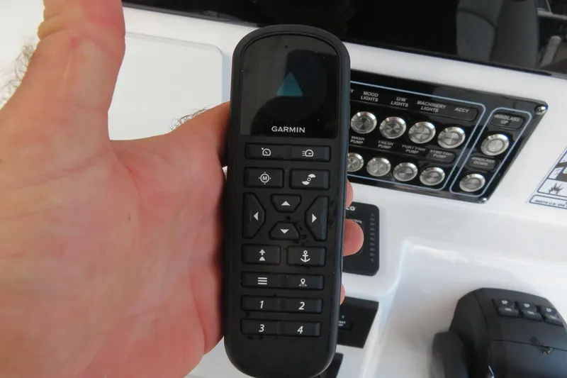 Slide: The Image of Hand holding Garmin remote on 2024 Sea Fox 288 Commander boat dashboard. - 16