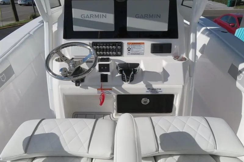 Slide: The Image of 2024 Sea Fox 288 Commander boat dashboard with Garmin displays and steering wheel. - 69