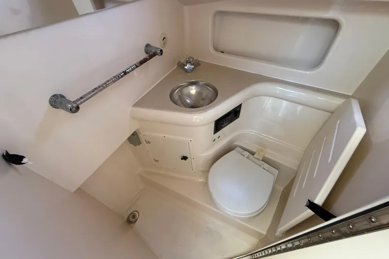 Slide: The Image of 2006 Pursuit 3370 Offshore boat bathroom with sink, toilet, and storage. - 14
