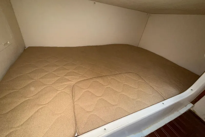 Slide: The Image of 2006 Pursuit 3370 Offshore cabin with beige mattress, showcasing cozy sleeping area. - 15