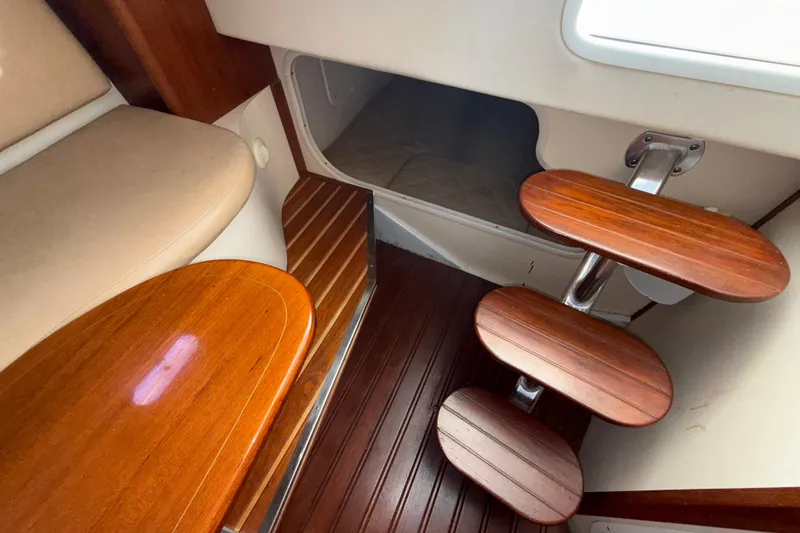 Slide: The Image of 2006 Pursuit 3370 Offshore cabin interior with wooden steps and seating area. - 16