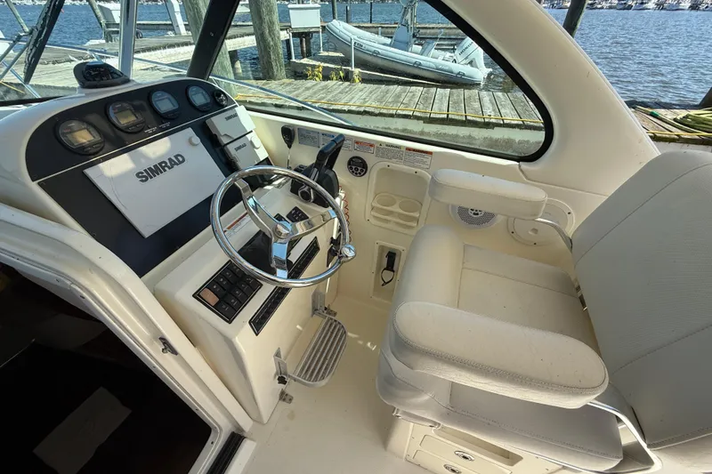 Slide: The Image of 2006 Pursuit 3370 Offshore helm with Simrad electronics, steering wheel, and comfortable seating. - 19