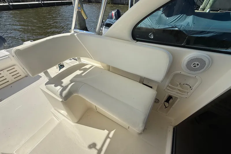 Slide: The Image of 2006 Pursuit 3370 Offshore boat interior with white seating and speaker. - 20