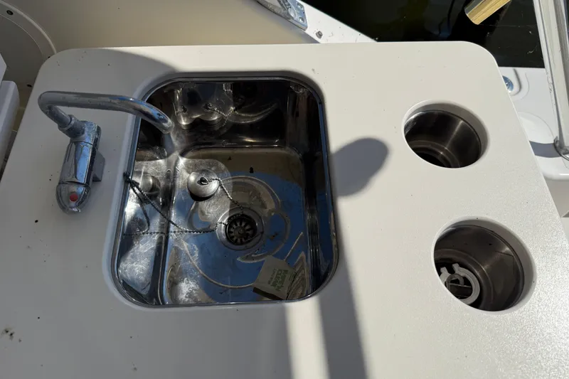Slide: The Image of 2006 Pursuit 3370 Offshore boat sink with faucet and cup holders. - 24
