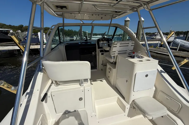 Slide: The Image of 2006 Pursuit 3370 Offshore boat interior with helm, seating, and dock view. - 28