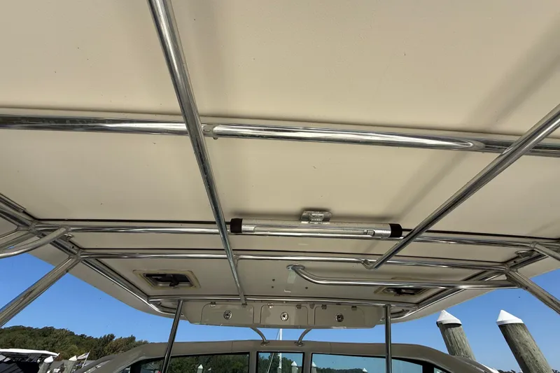 Slide: The Image of 2006 Pursuit 3370 Offshore boat canopy with metal framework and clear sky background. - 29