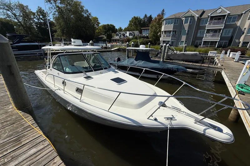 Slide: The Image of 2006 Pursuit 3370 Offshore boat docked at a marina with waterfront homes. - 3