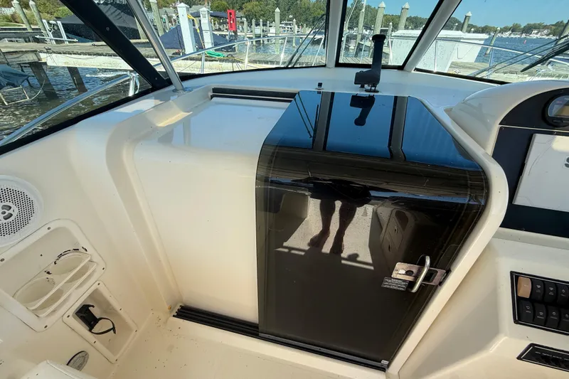 Slide: The Image of 2006 Pursuit 3370 Offshore boat interior with black cabin door and control panel. - 30