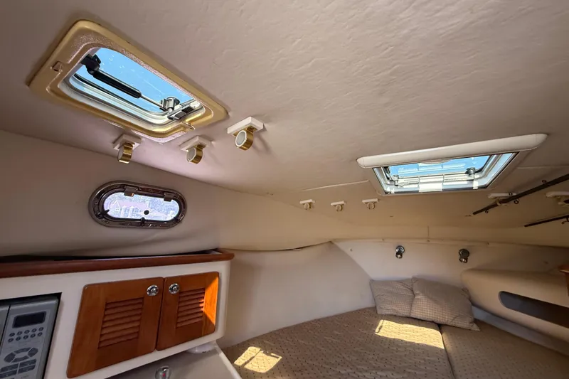 Slide: The Image of Interior cabin of 2006 Pursuit 3370 Offshore boat with skylights and cozy bedding. - 34