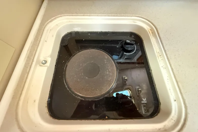 Slide: The Image of Stove burner on 2006 Pursuit 3370 Offshore boat, set in a compact kitchen area. - 36