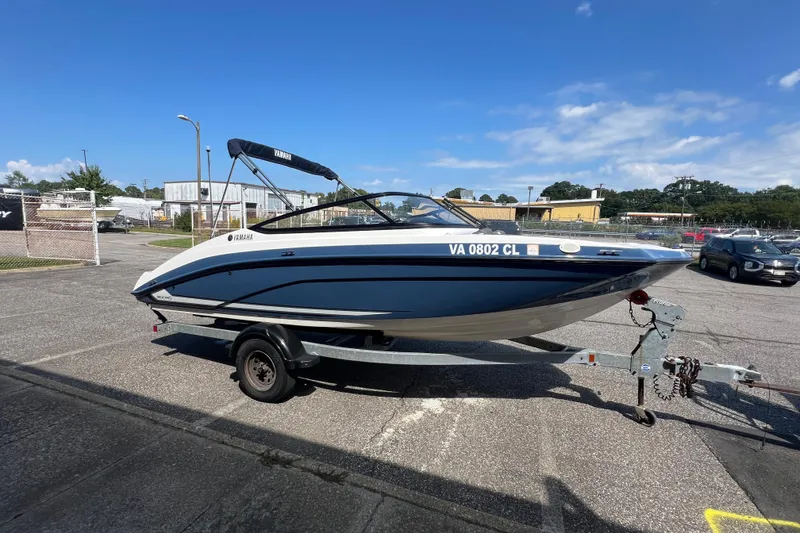 Slide: The Image of 2020 Yamaha SX190 boat on trailer in parking lot under clear blue sky. - 11