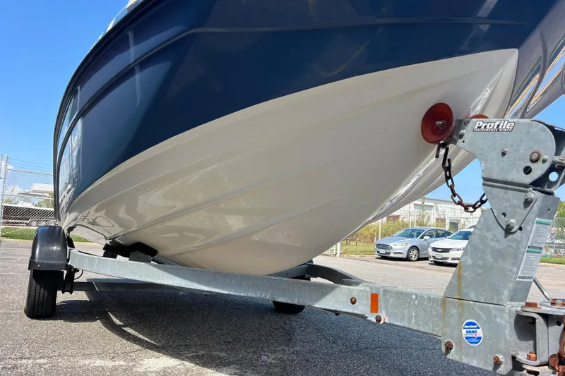 Slide: The Image of 2020 Yamaha SX190 boat on trailer, parked outdoors, showcasing hull and trailer details. - 13