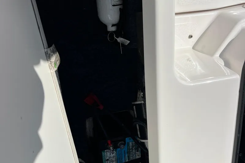 Slide: The Image of 2020 Yamaha SX190 boat interior storage compartment with visible battery and fire extinguisher. - 25