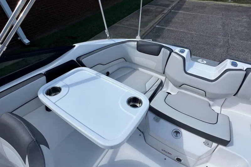 Slide: The Image of 2020 Yamaha Boats SX190 interior with seating and table, featuring cup holders. - 32