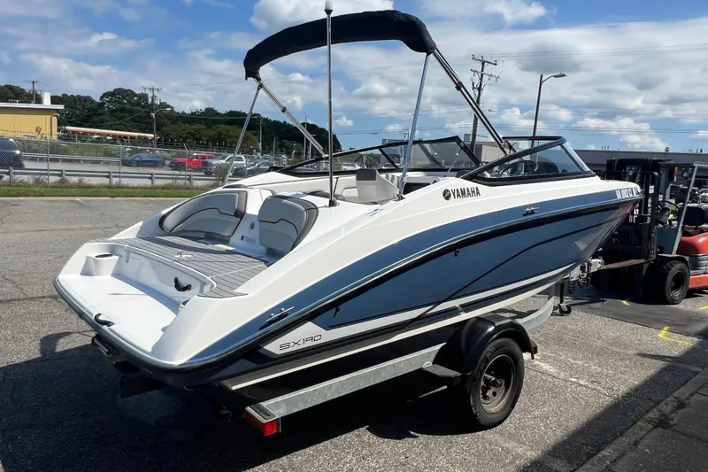 Slide: The Image of 2020 Yamaha Boats SX190 on trailer, parked outdoors under a blue sky. - 9