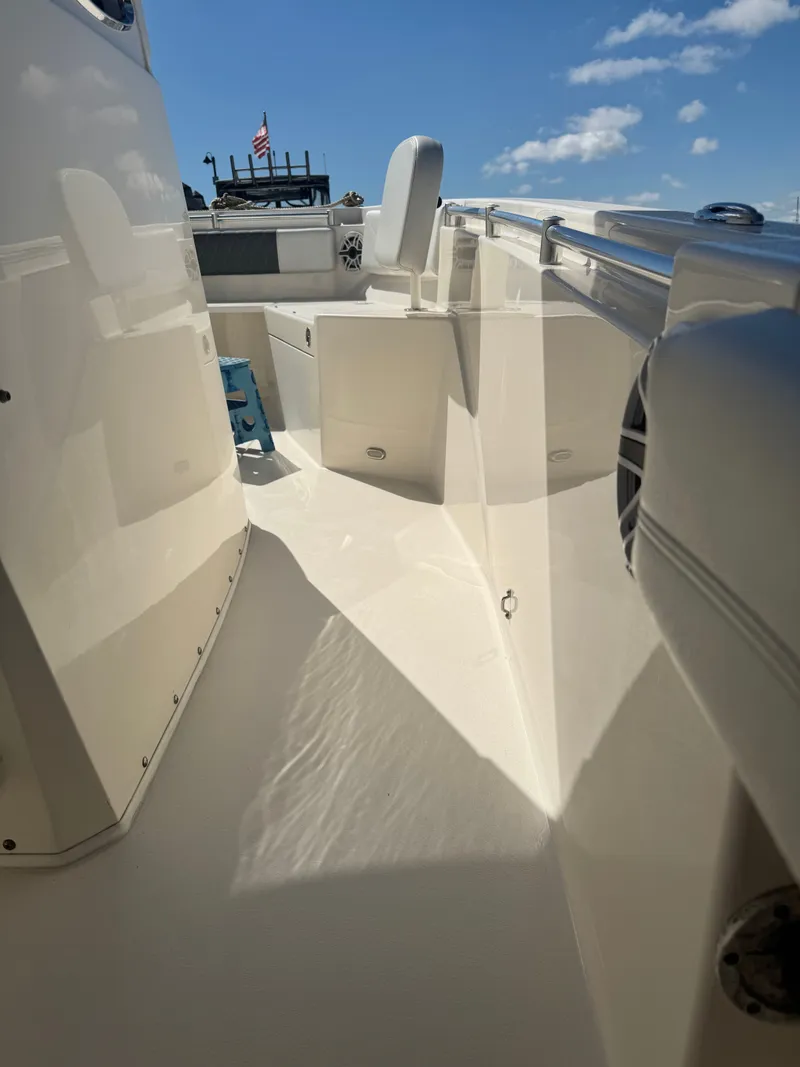 Slide: The Image of 2020 Cobia 240 Center Console boat interior with seating, under a clear blue sky. - 20