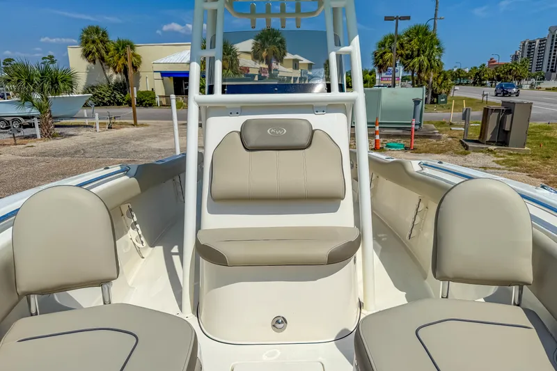 Slide: The Image of 2021 Key West 239 FS boat interior with beige seating and console, parked outdoors. - 19